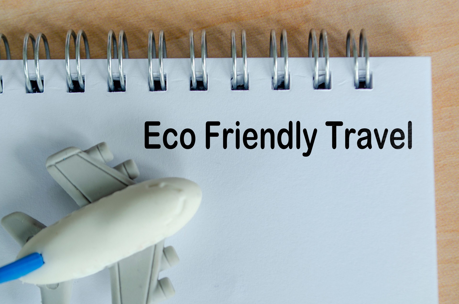 Eco Friendly Travel text on white notepad. Green travel planning and environmental awareness.